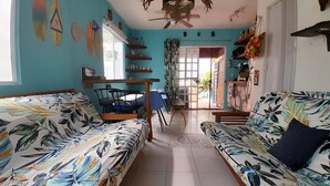 A living room with two sofas, a dining table, and a ceiling fan. - Beach house with jacuzzi (Playa del Carmen)