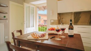 A dining table with bread, a bottle of wine, and glasses. - Apartment with balcony - La Rosa nel Borgo (La Morra)