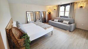 A modern bedroom with a bed, a grey sofa, and a large mirror. - AP406 - VILLA JAZMIN BELLAVISTA (Nerja)