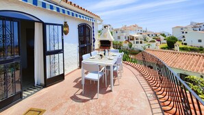A terrace with a table and chairs, a barbecue grill, and a view of the neighborhood. - AP406 - VILLA JAZMIN BELLAVISTA (Nerja)