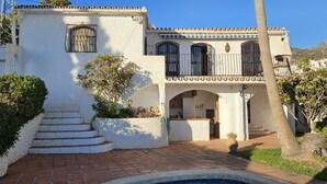 A two-story building with a white stucco exterior, a patio area with a small pool, and a view of the surrounding neighborhood. - AP406 - VILLA JAZMIN BELLAVISTA (Nerja)