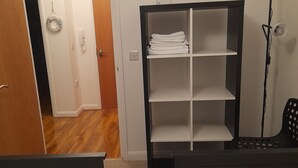 Ein Hotelzimmer mit zwei Betten, einem Schrank, einem Schreibtisch und einer Lampe.