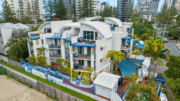 Un hôtel moderne doté de nombreux balcons, d’un espace piscine et offrant une vue sur la plage.