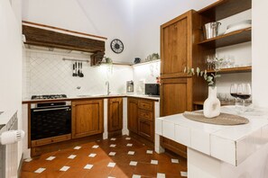A kitchen with wooden cabinets, a gas stove, a microwave, and a sink. - Apartments Florence -Faenza Terrace (Florence)