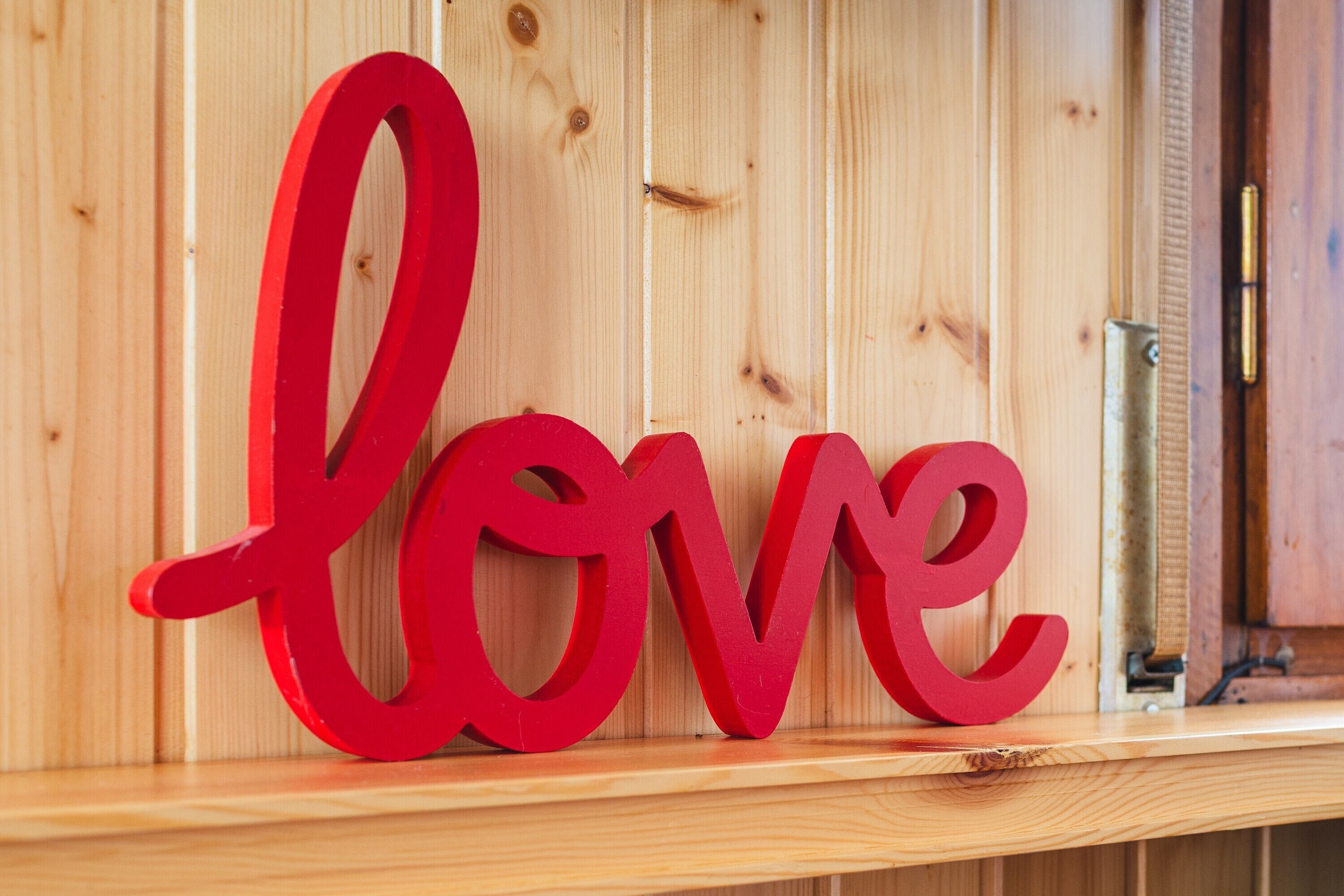 Un estante de madera con un letrero rojo que dice 'love'.