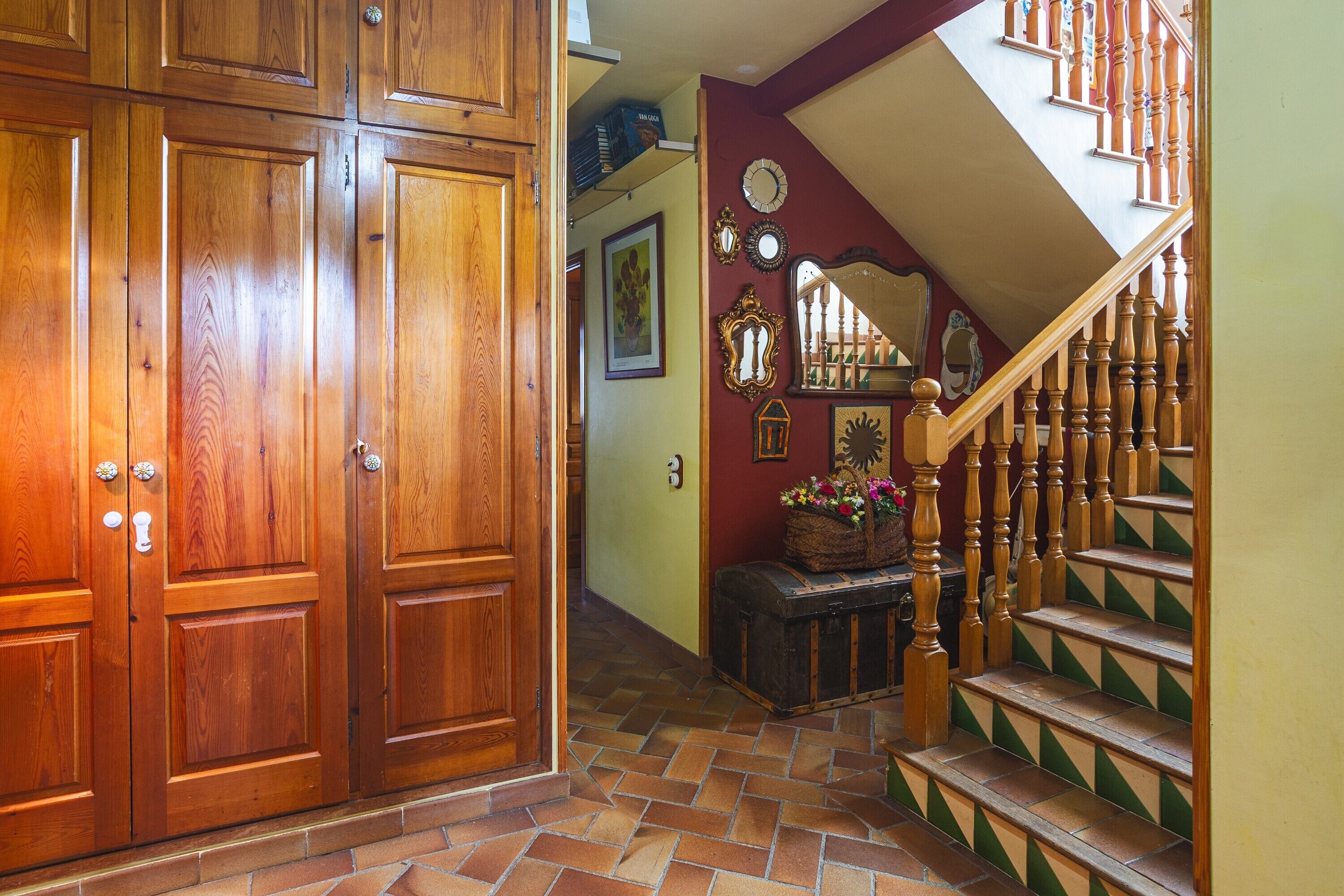Eine Holztür mit zwei Flügeln, eine Treppe mit Holzwand und ein Fliesenboden.