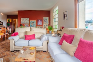 Una sala de estar con un conjunto de sofá, una mesa de centro y un comedor con sillas y una mesa.