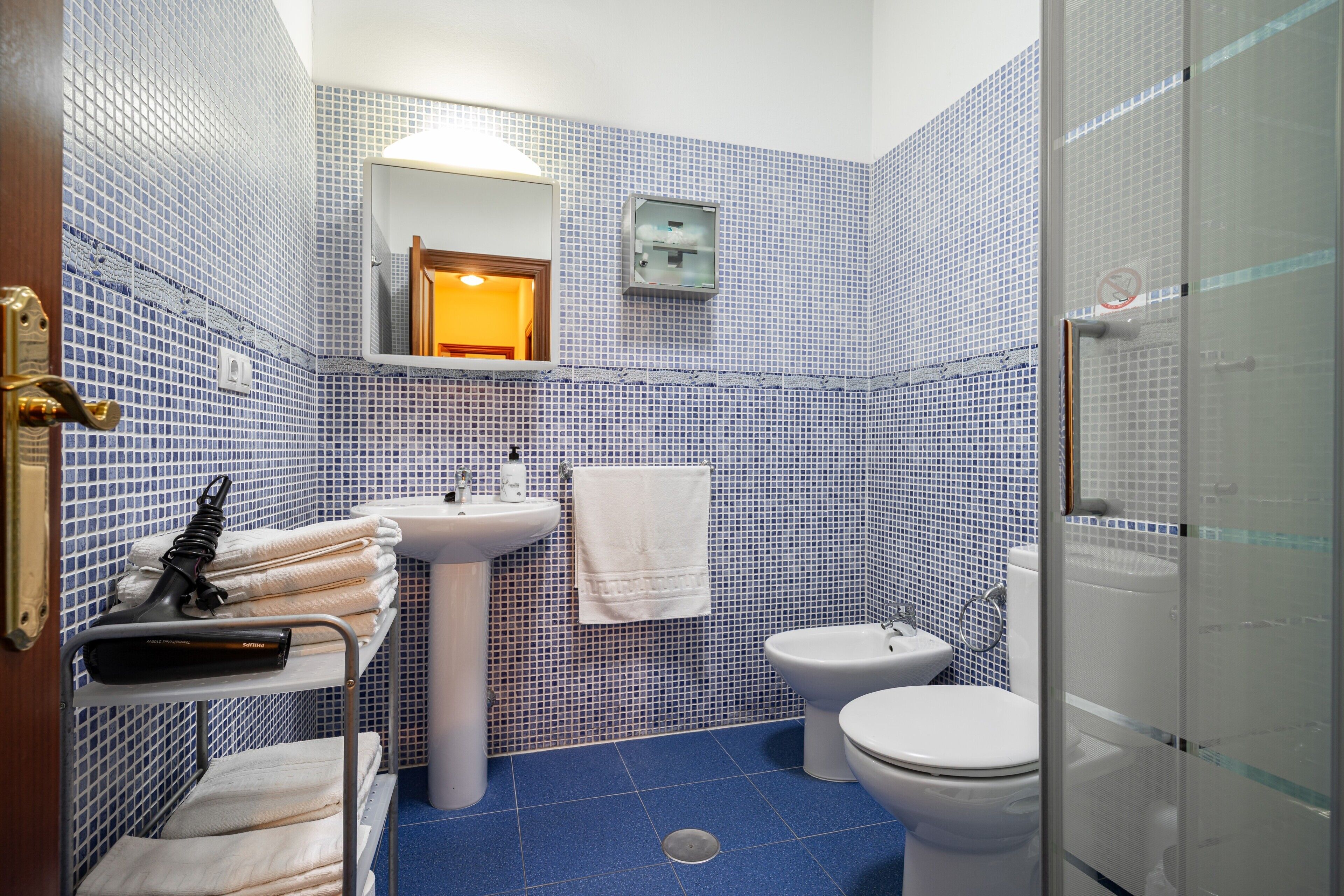 A bathroom with a sink, toilet, and shower area.