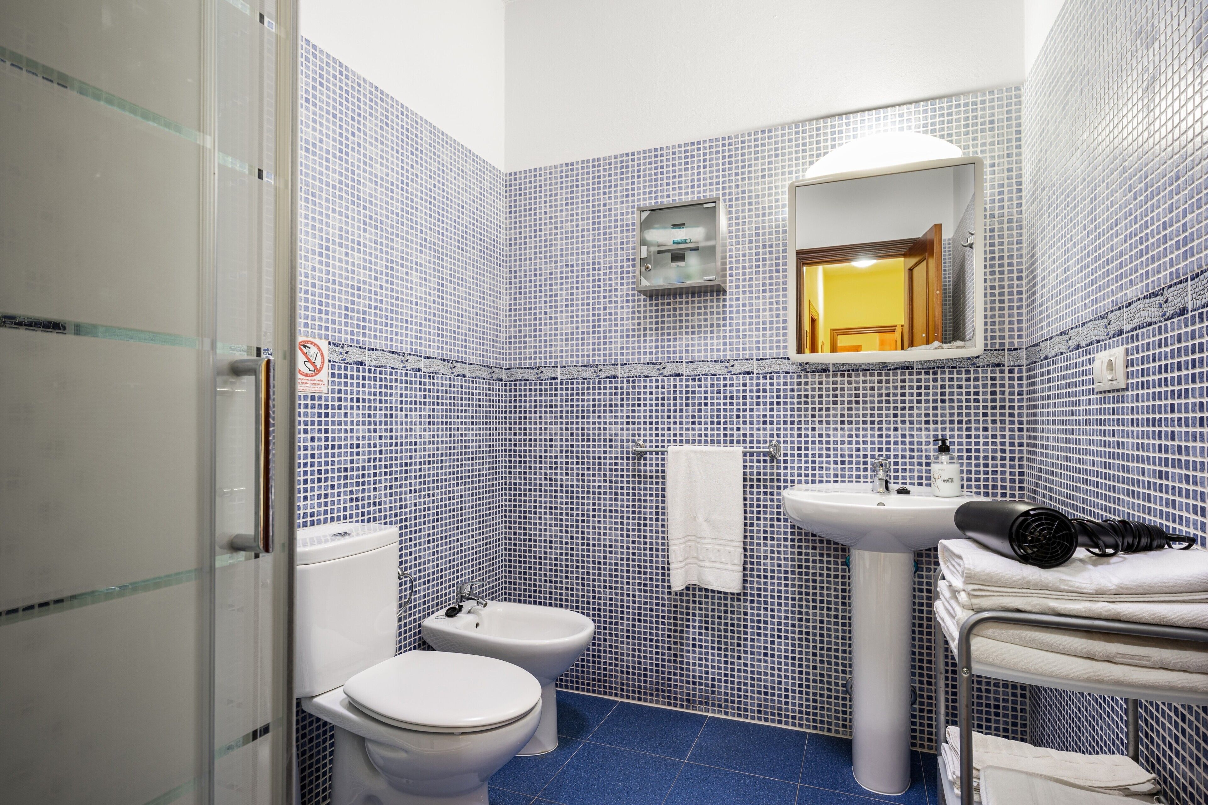 Un baño con inodoro, lavabo, toallero y bidé.