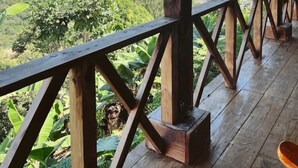 Une terrasse en bois offrant une vue sur un paysage montagneux.