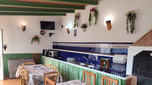 A restaurant with a dining area, kitchen, and a brick oven. - Country House 'El Serrano' with Mountain View, Wi-Fi and Air Conditioning (Murcia)