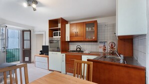 A modern kitchen with wooden cabinets, a microwave, stove, and a sink.
