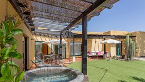 A hot tub, patio furniture, and a well-maintained lawn in a residential setting. - El Refugio Vacation Home with Mountain Views, Private Pool, and Wi-Fi (La Oliva)