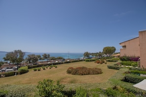 Une vue sur la côte, avec un espace de stationnement, un bâtiment doté d’un toit plat et un jardin bien entretenu.