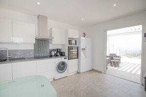 A modern kitchen with a washing machine, a refrigerator, and a coffee maker. - Apartment 'Bel Neuf, Climatisé' with Sea View, Shared Pool and Wi-Fi (Albitreccia)