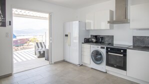 Een moderne keuken met een ingebouwde wasmachine, oven en koffiezetapparaat.