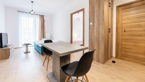 Una sala moderna con una mesa de comedor, un sofá y un televisor.