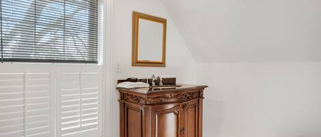 Ein Badezimmer mit einem Holz-Waschtisch, einem Spiegel und einer roten Teppich.