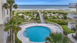 A pool area with a view of the beach and ocean.