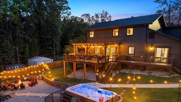 A wooden deck with outdoor seating and a hot tub.