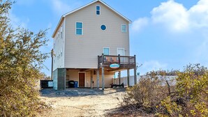 A two-story house with a balcony, a front door, and a visible garage. - Oceanside, Wild Horses, Private Pool, Hot Tub -4x1941, A Sense of Porpoise (Carova Beach)