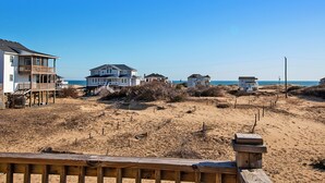 A beachfront property with multiple houses, a wooden deck, and a sandy beach. - Oceanside, Wild Horses, Private Pool, Hot Tub -4x1941, A Sense of Porpoise (Carova Beach)