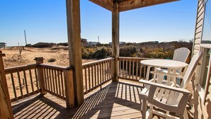 A wooden deck with a view of a sandy beach and distant buildings. - Oceanside, Wild Horses, Private Pool, Hot Tub -4x1941, A Sense of Porpoise (Carova Beach)