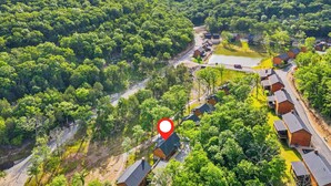 An aerial view of a rural area with a cluster of houses, a dirt road, and a body of water. - Private Hot Tub & Indoor Pool Cabin, Steps to Pond, Free Daily Tickets Near Thunder Ridge (Hollister)