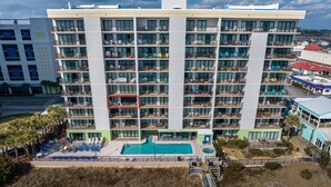 A multi-story hotel with balconies, a swimming pool, and a beach area. - Oceanfront Pool-3BD Family Friendly Condo-Cherry Grove (North Myrtle Beach)