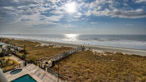 A beach view with a wooden boardwalk leading to a pool area. - Oceanfront Pool-3BD Family Friendly Condo-Cherry Grove (North Myrtle Beach)