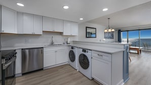 A modern kitchen with white cabinets, stainless steel appliances, and a large island. - Oceanfront Pool-3BD Family Friendly Condo-Cherry Grove (North Myrtle Beach)