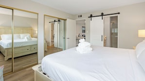 A hotel room with a large bed, a wardrobe, a mirror, and a bathroom visible through an open door. - Beach Retreat, Free Wifi 308A (Oceanside)