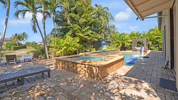 Zona de piscina con jacuzzi, sillas de descanso y una canasta de baloncesto.