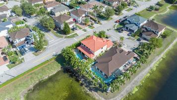 A residential area with houses, a swimming pool, and a body of water.