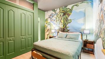 Un dormitorio con una cama, una mesita de noche, una lámpara y un armario verde.