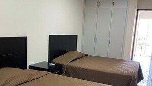 A hotel room with two beds, a nightstand, a wardrobe, and a view of the outside. - Double Suite- 500m from "La Lomita". (Culiacán Rosales)