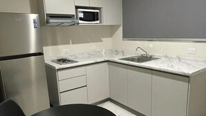 A modern kitchen with a refrigerator, microwave, sink, and marble countertops. - Double Suite- 500m from "La Lomita". (Culiacán Rosales)