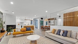 Una sala moderna con un sofá, una mesa de centro y un comedor con sillas y una mesa.