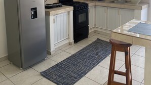 A compact kitchen with a refrigerator, stove, and sink.