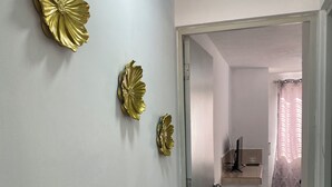 A hallway with a door leading to a kitchen area.