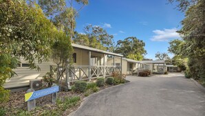A caravan park with multiple caravan-style buildings, a paved driveway, and a sign reading "CRAYFISH COURT". - 2 Bedroom Superior Villa (Metung)