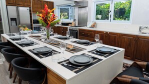 A modern kitchen with a central island, stainless steel appliances, and wooden cabinets.