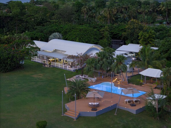 A large house with a swimming pool, outdoor seating, and a covered patio area. - Fiji's Best Family Vacation Home . Spectacular Ocean Views w/Chef's Kitchen ! (Western Division)