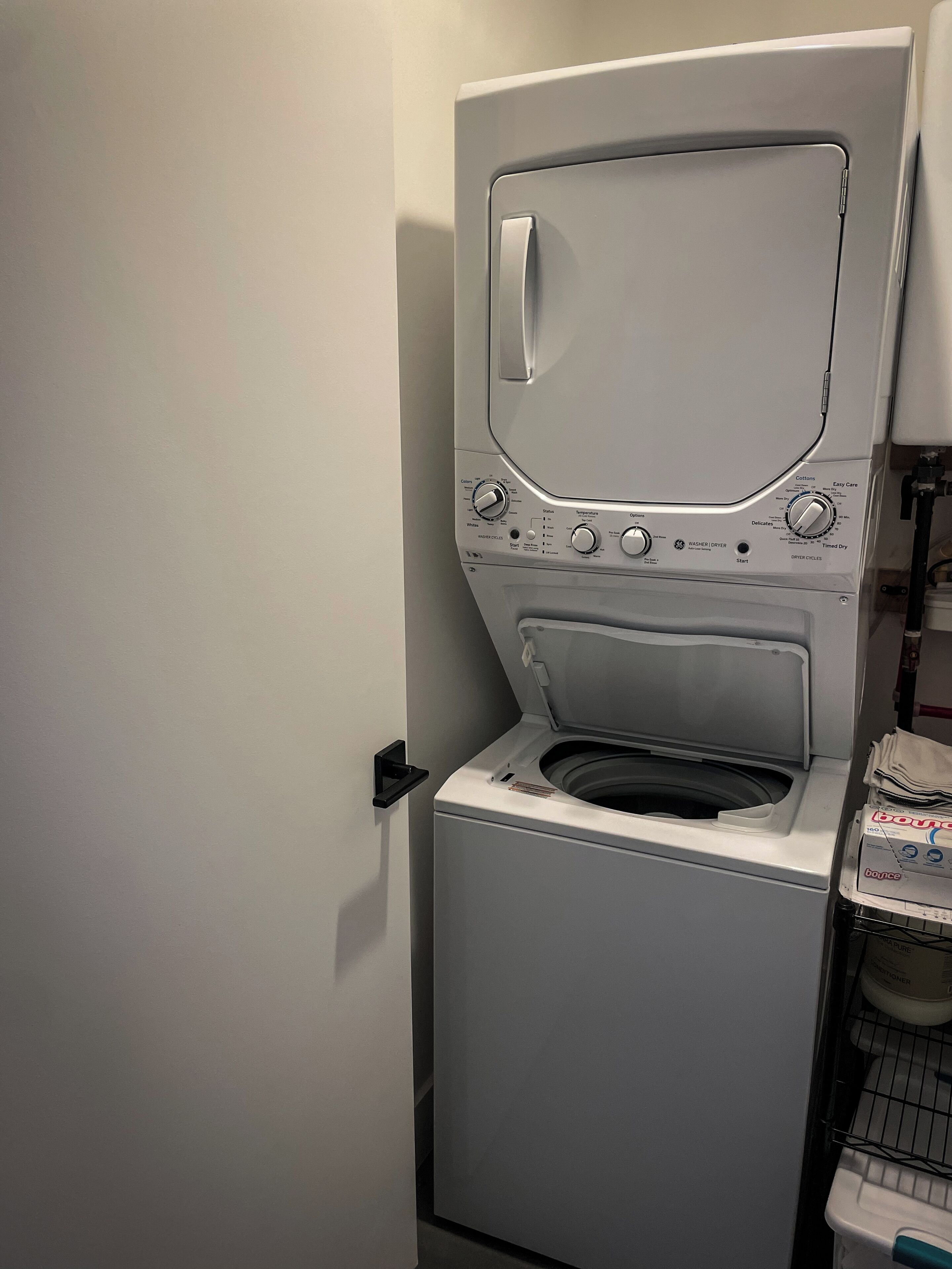 Eine Waschmaschine mit Frontlader, Bedienfeld, Tür und Ablagefläche für Waschmittel.