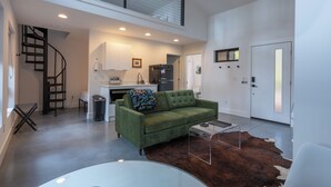 A modern living room with a green sofa, a glass coffee table, and a brown leather rug. - **Cleaning Fee Included** Mini modern cabin nestled in the peaceful hills between Jackson and Putnam County, minutes away from CUMMINS FALLS STATE PARK. Designed for comfort and style, this vacation rental seamlessly blends modern charm with wooded s (Cookeville)