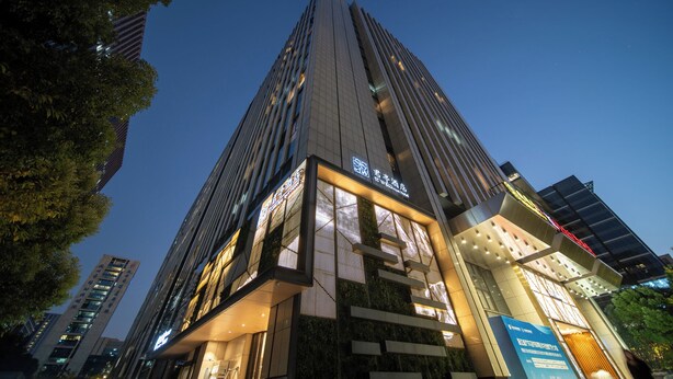 A modern high-rise hotel with a prominent entrance and signage. - SSAW Boutique Hotel Hangzhou Qianjiang New City Jinjiang Subway Station Branch (Hangzhou)