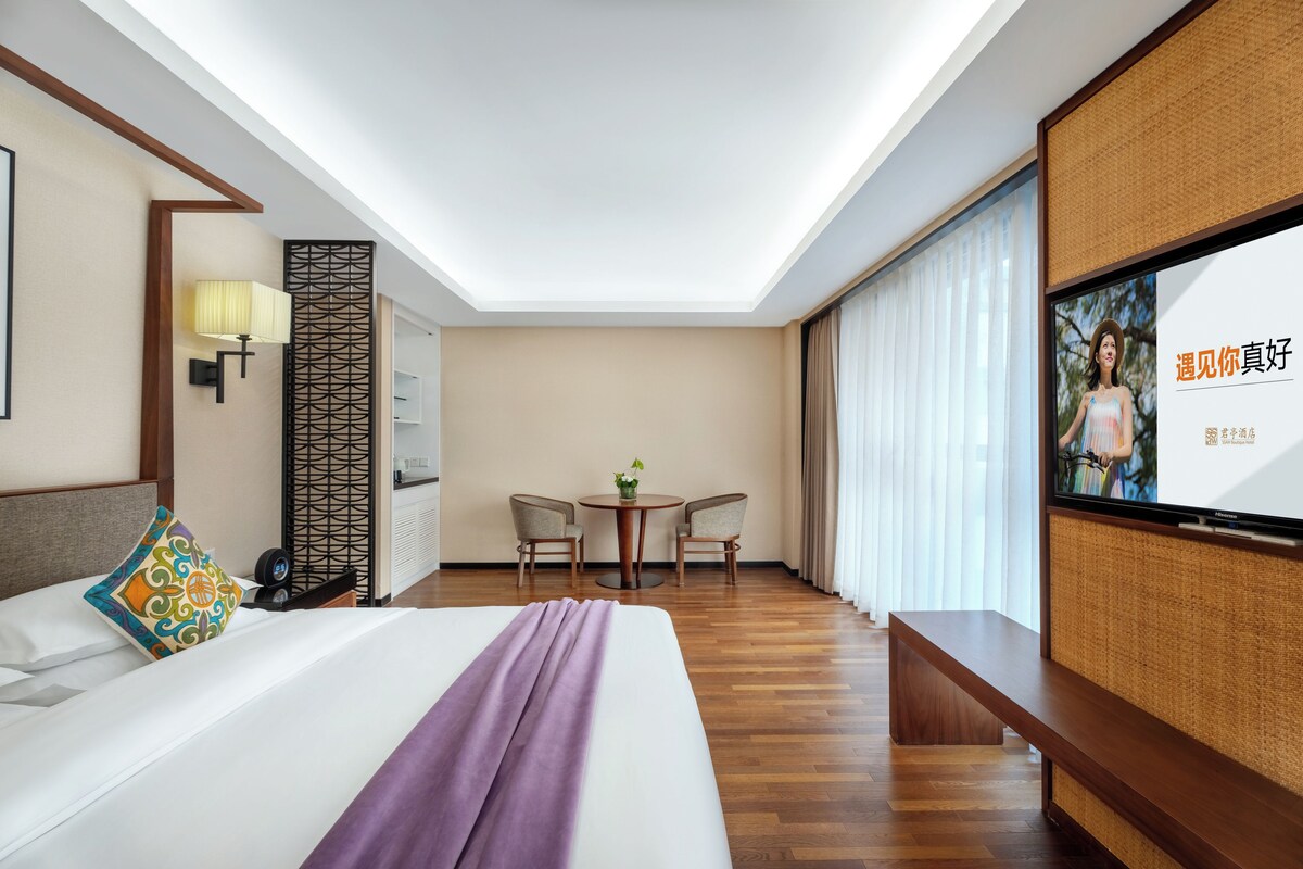 Une chambre d’hôtel avec un lit, une télévision, un bureau et une chaise.
