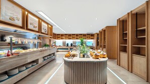 A modern buffet setup with multiple serving stations, a central island, and wooden shelving units. - SSAW Boutique Hotel Hangzhou Qianjiang New City Jinjiang Subway Station Branch (Hangzhou)