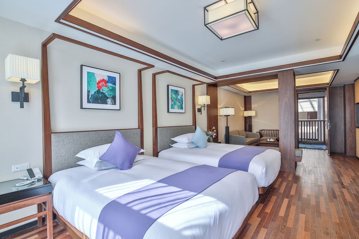 Une chambre d’hôtel avec deux lits, un plancher en bois et une vue sur l’espace extérieur.