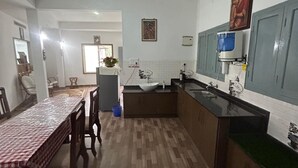 Une cuisine spacieuse avec un coin repas, un plancher en bois et un ventilateur de plafond.